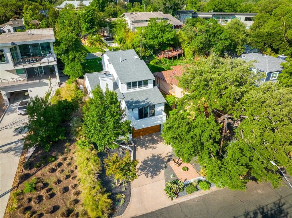 an aerial view of a house with a yard potted plants and large tree