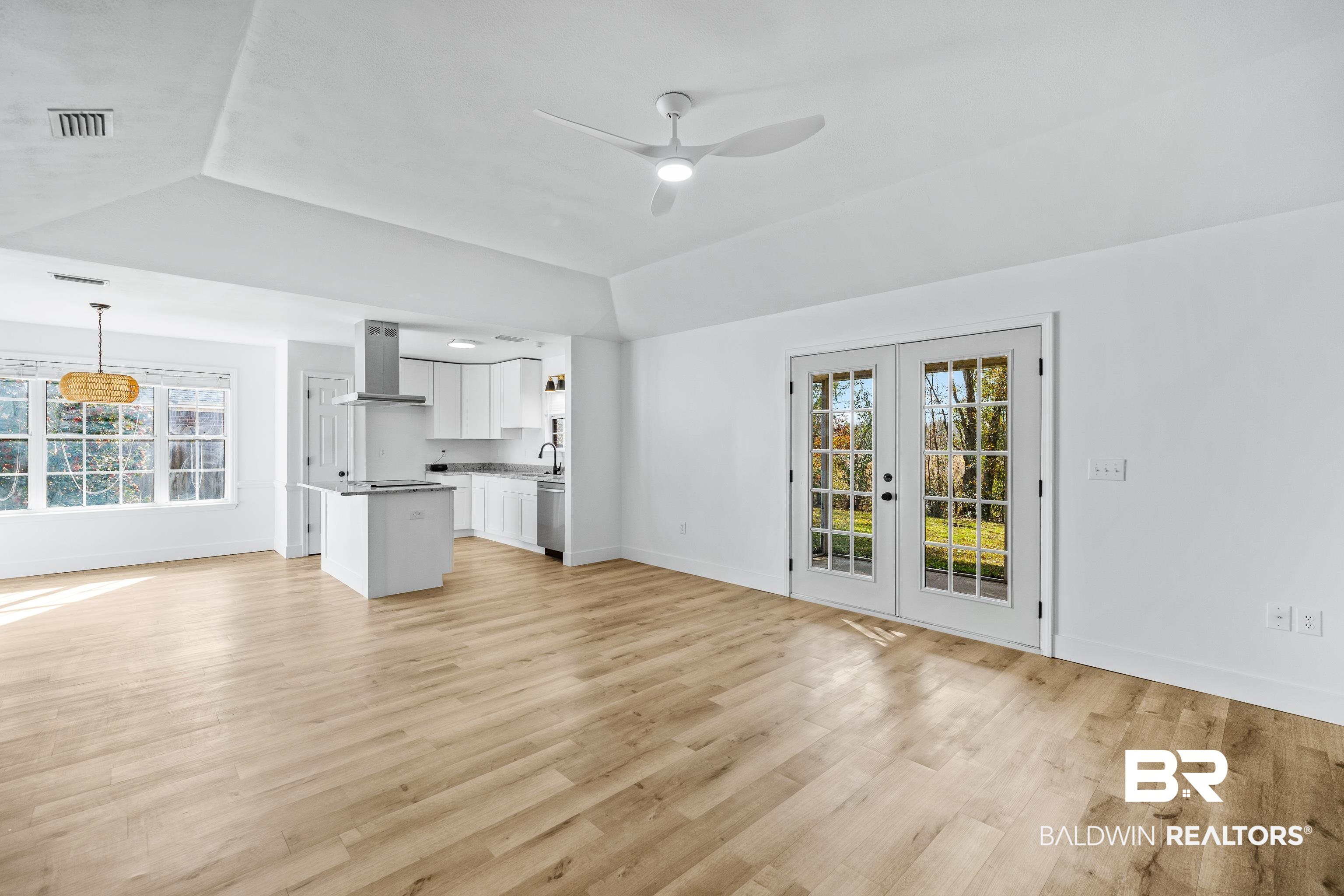 9243 Brookshire Loop Daphne, AL 36526 - Photo 6 of 26 Unfurnished living room with vaulted ceiling, ceiling fan, light hardwood / wood-style floors, and french doors