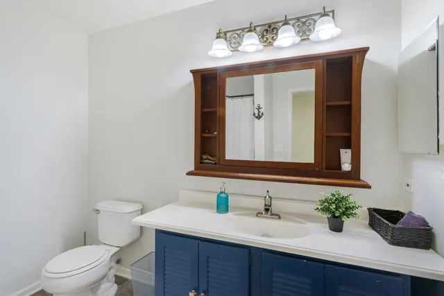 a bathroom with a toilet sink and mirror