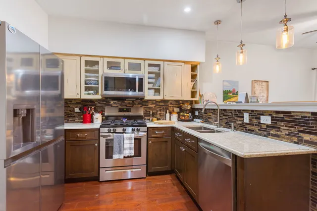 a kitchen with stainless steel appliances granite countertop a stove and a sink