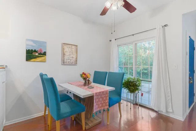 a dining room with furniture potted plants and wooden floor