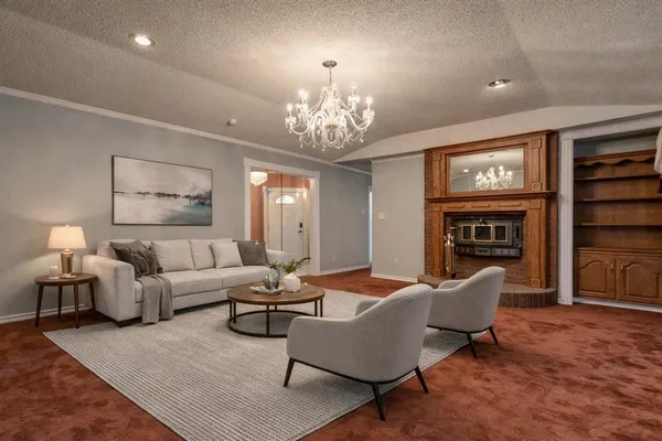 a living room with furniture a fireplace and a chandelier