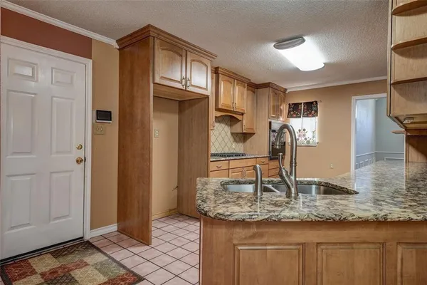a kitchen with stainless steel appliances granite countertop a sink and a refrigerator