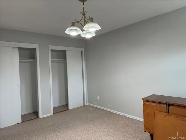 an empty room with a chandelier fan