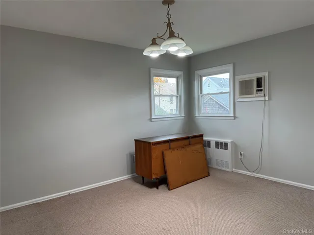 an empty room with windows and cabinet