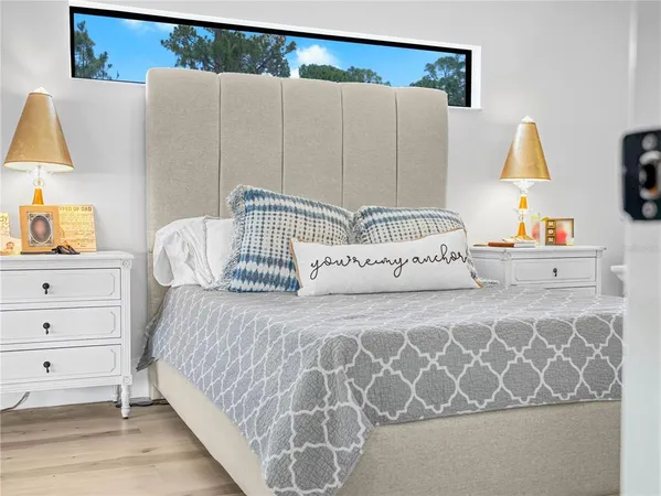 a bedroom with a bed and a lamp on dresser