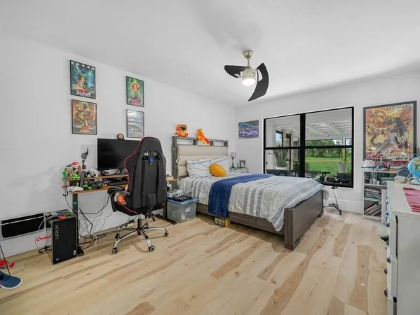 a bedroom with a bed a large window and book self