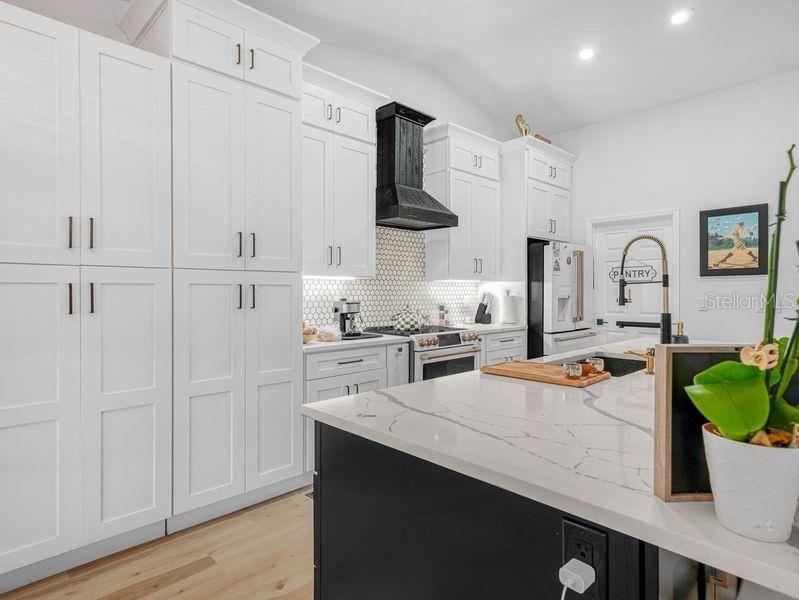1850 South Lake Reedy Boulevard Frostproof, FL 33843 - Photo 7 of 36 a kitchen with white cabinets and black appliances