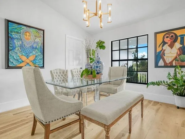 a view of a dining room with furniture a chandelier and wooden floor
