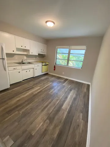 a big room with wooden floor and windows