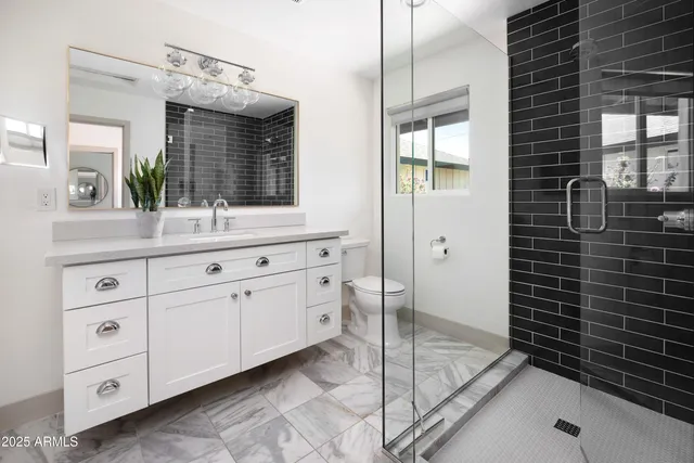 a bathroom with a double vanity sink mirror and shower
