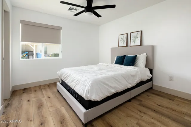 a large bed sitting in a bedroom next to a window