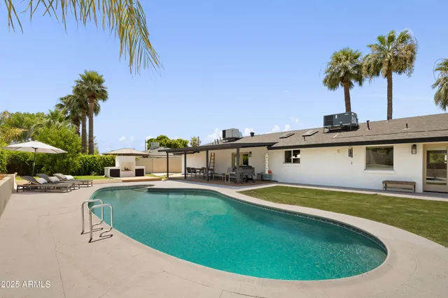 a view of a house with swimming pool and sitting area