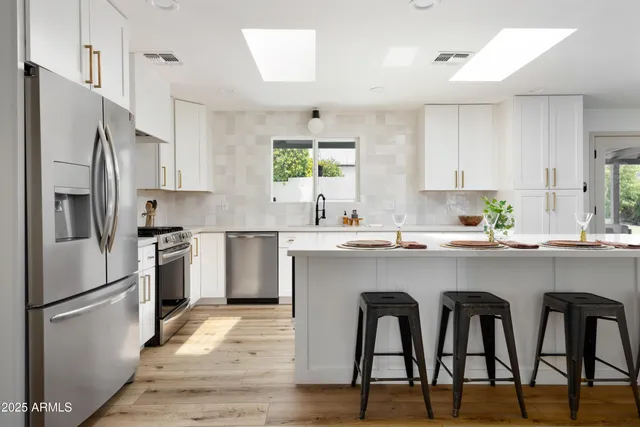 a kitchen with cabinets stainless steel appliances and a window