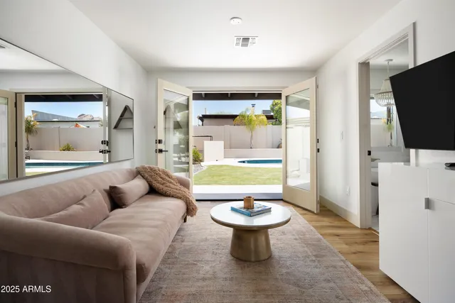 a living room with furniture a flat screen tv and a large window