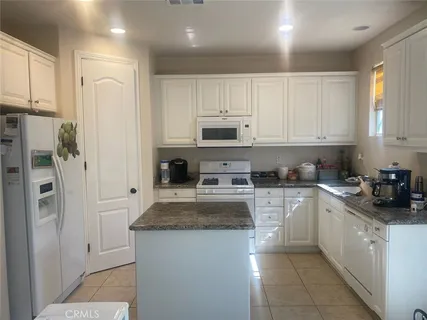 a kitchen with stainless steel appliances granite countertop a refrigerator sink and cabinets