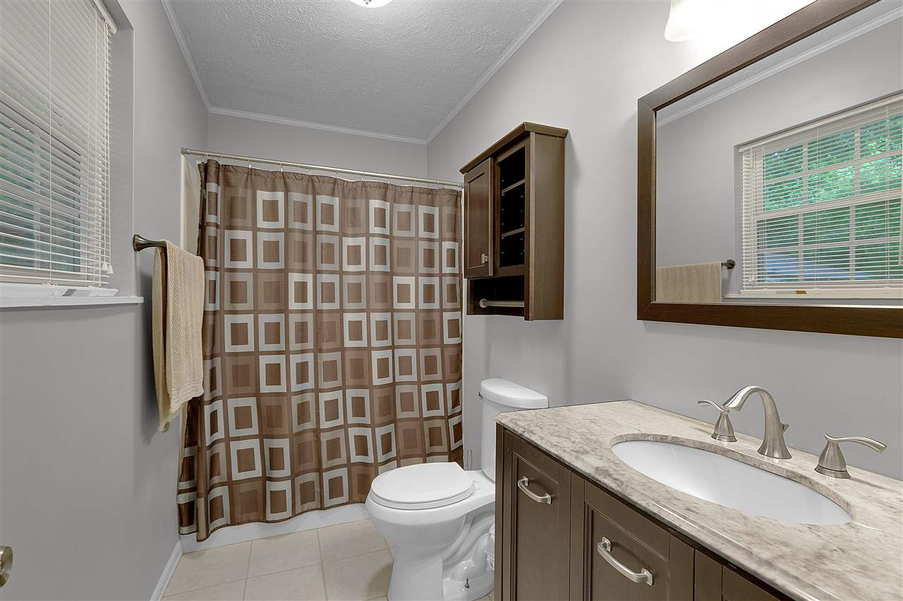 58 John Brown Road Beech Bluff, TN 38313 - Photo 11 of 18 a bathroom with a granite countertop toilet sink and mirror