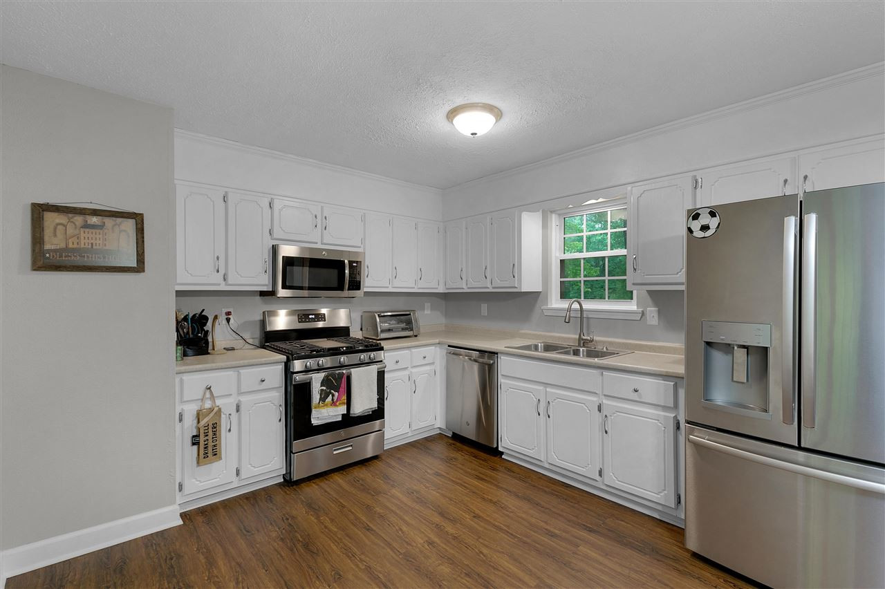58 John Brown Road Beech Bluff, TN 38313 - Photo 6 of 18 a kitchen with stainless steel appliances white cabinets and wooden floors