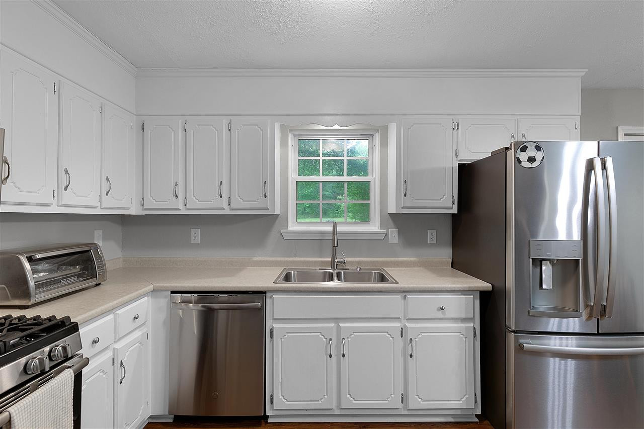 58 John Brown Road Beech Bluff, TN 38313 - Photo 7 of 18 a kitchen with white cabinets and stainless steel appliances