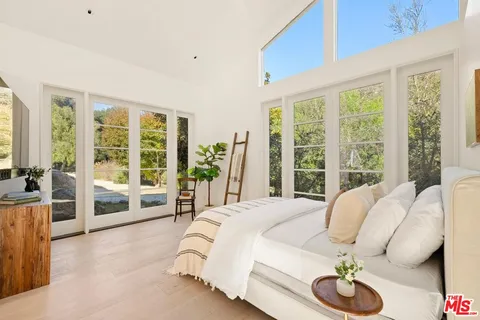 a spacious bedroom with a large bed and a large window