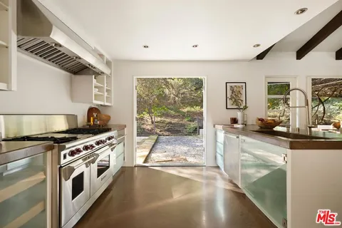 a kitchen with stainless steel appliances kitchen island granite countertop a stove and a refrigerator