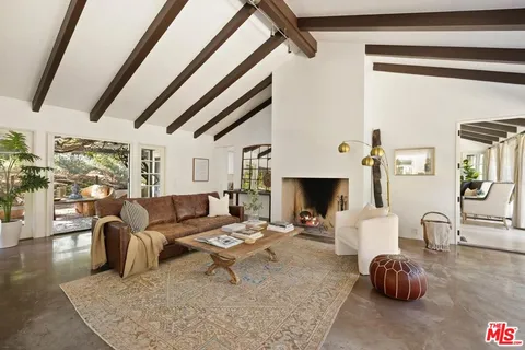 a living room with fireplace furniture and a rug