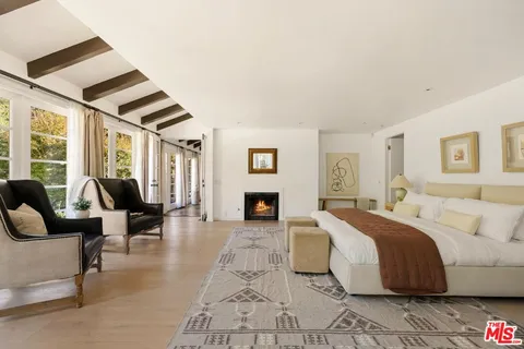 a spacious bedroom with a bed and glass windows