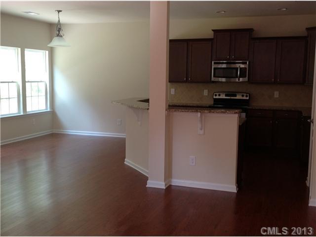 78102 Rillstone Drive, Unit 203 Lancaster, SC 29720 - Photo 5 of 9 a kitchen with granite countertop a stove a microwave and a refrigerator