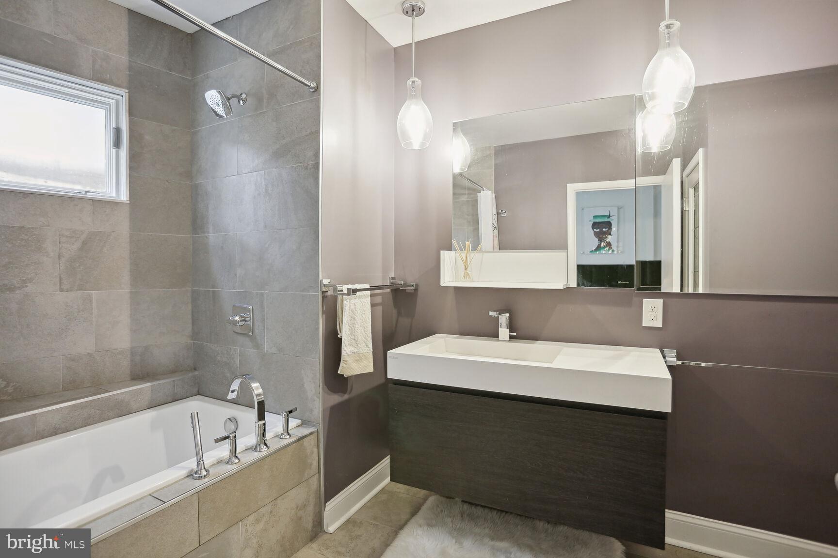 1700 Kalorama Road Northwest, Unit 312 Washington, DC 20009 - Photo 9 of 17 a bathroom with a bathtub a sink and a mirror