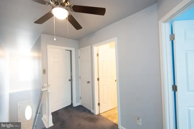 an empty room with a window and a ceiling fan