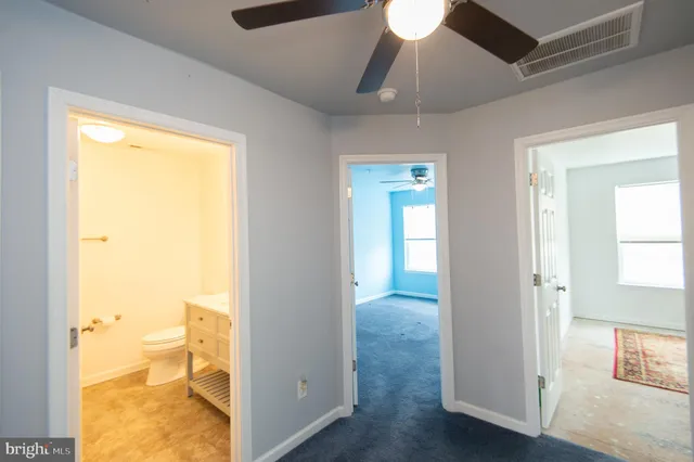 an empty room with windows and fan