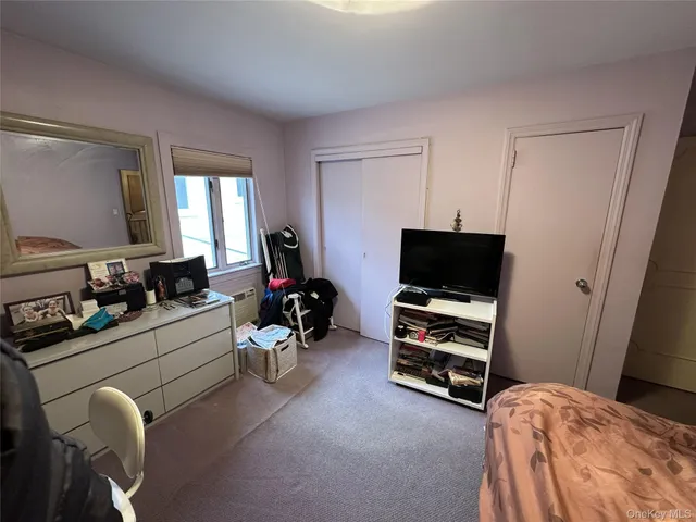 a bedroom with furniture and a large window