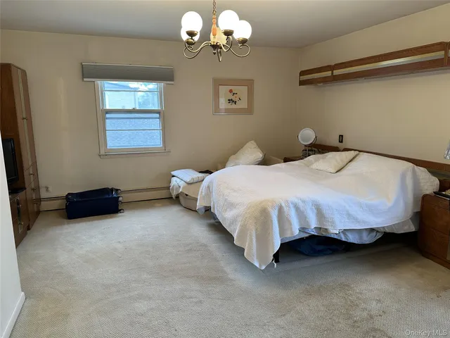 a bedroom with a bed dresser and a window