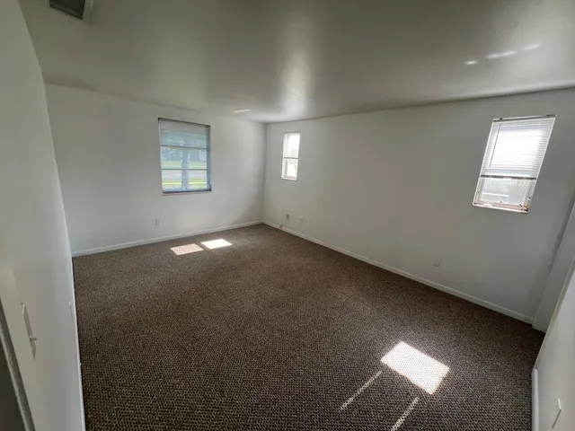 an empty room with windows and closet