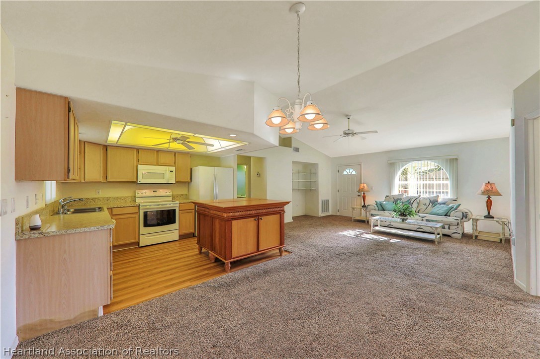 4441 Leaf Road Sebring, FL 33875 - Photo 6 of 21 a view of a kitchen with kitchen island a large window cabinets and stainless steel appliances
