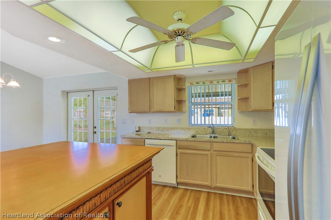 4441 Leaf Road Sebring, FL 33875 - Photo 7 of 21 a kitchen with a sink a refrigerator and chandelier