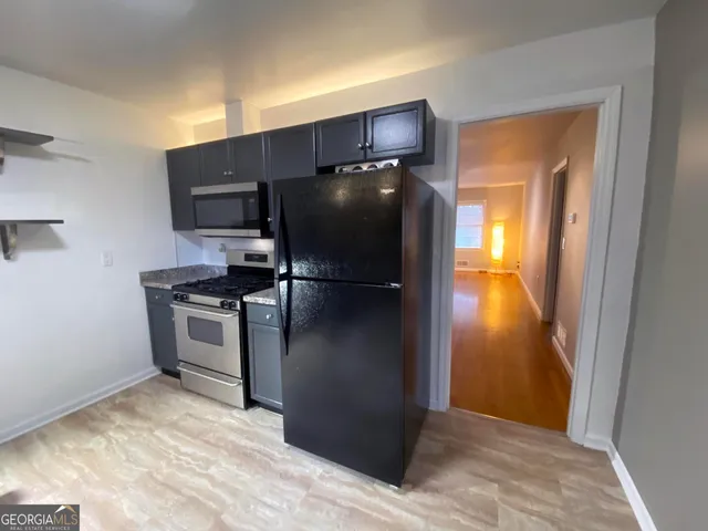 a kitchen with a refrigerator and a stove