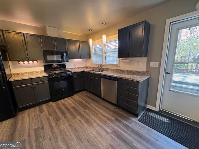 a kitchen with stainless steel appliances granite countertop a stove a sink and a microwave