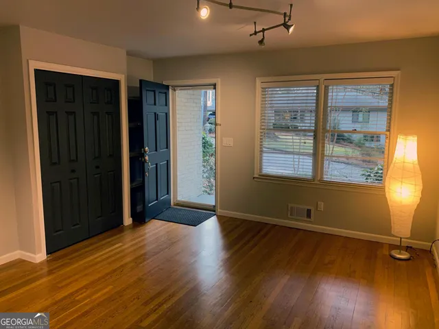 an empty room with wooden floor and windows