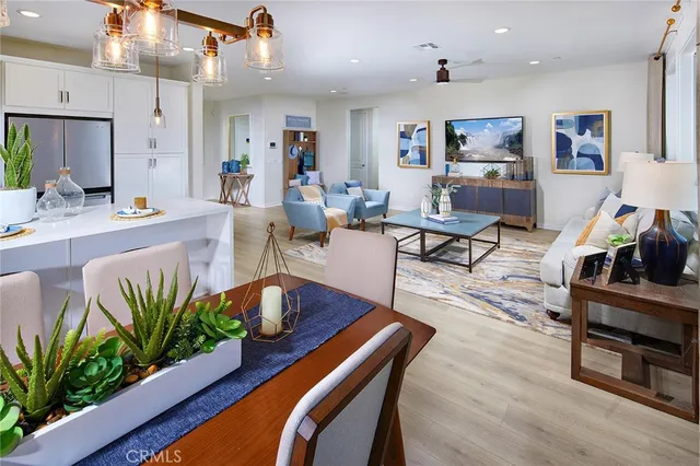 a living room with furniture potted plant and kitchen view