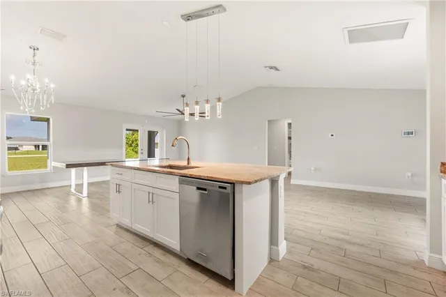 a large kitchen with stainless steel appliances a large counter top a stove a refrigerator and a sink