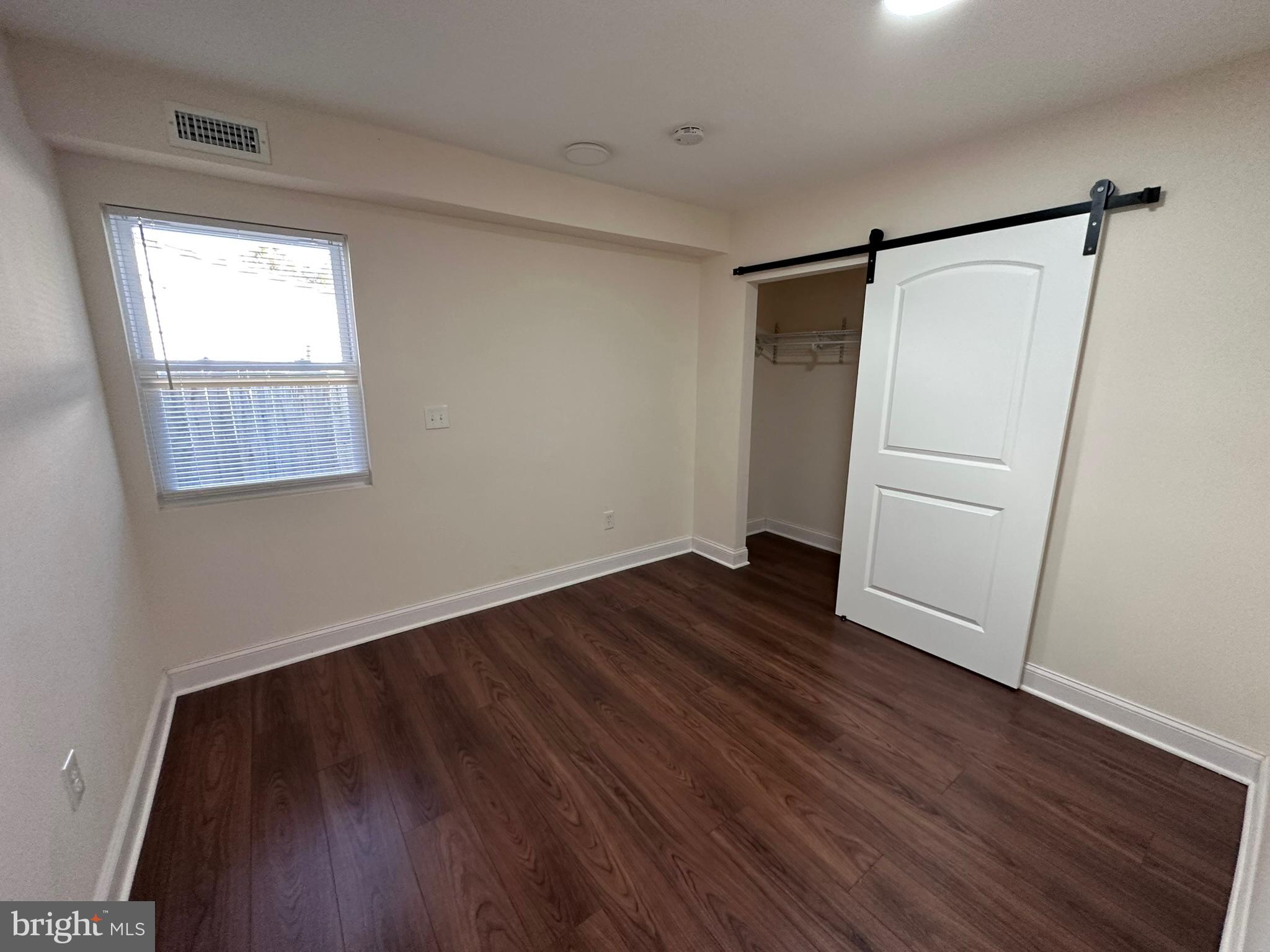 1107 Navahoe Drive Silver Spring, MD 20903 - Photo 18 of 26 an empty room with wooden floor and a window