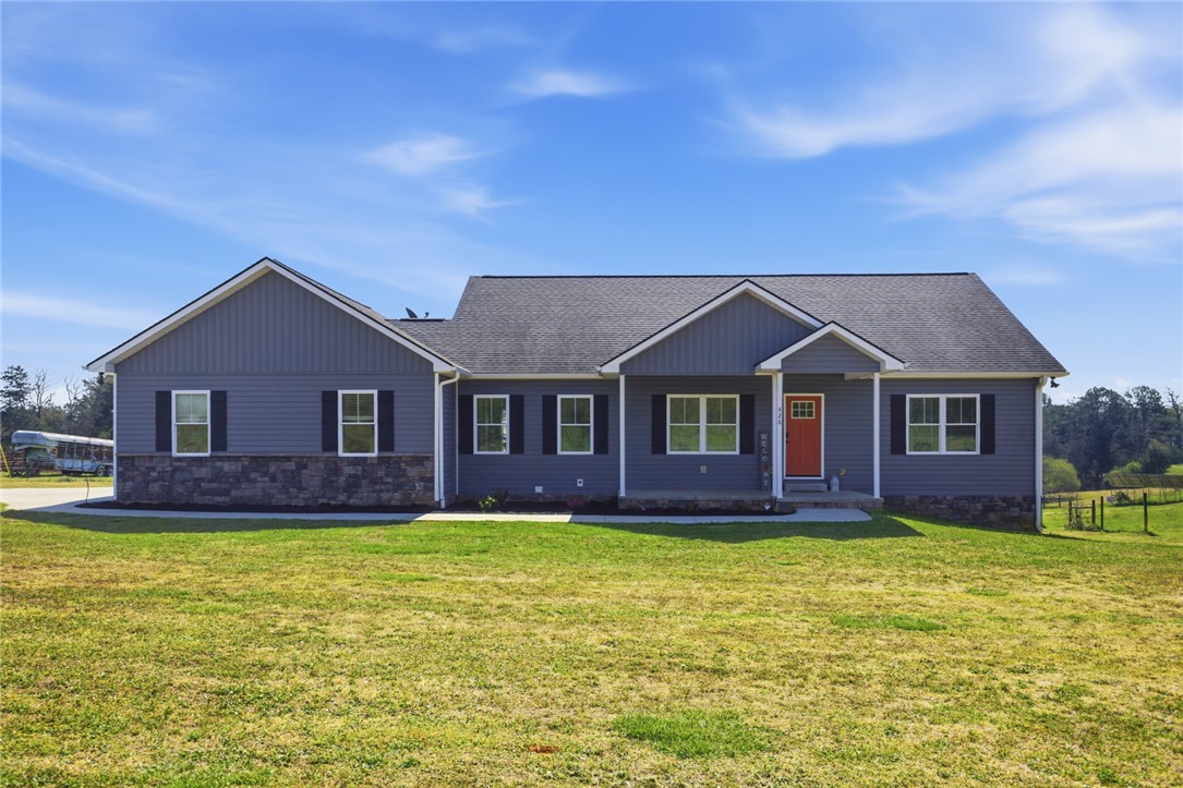 This charming residence features a well-maintained lawn and a welcoming entryway.