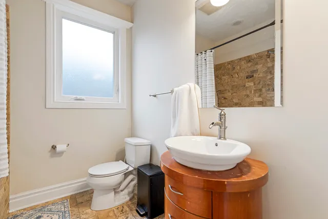 a bathroom with a toilet sink and mirror