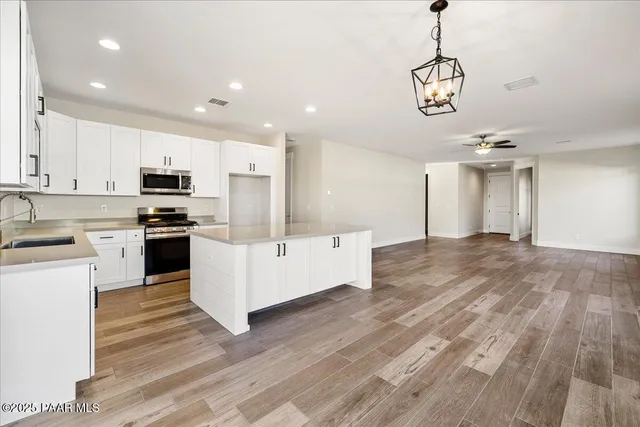 a kitchen with stainless steel appliances granite countertop a refrigerator a stove and a sink