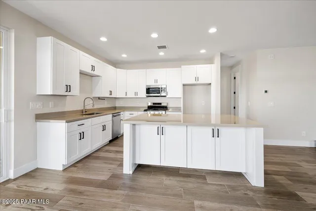 a kitchen with white cabinets and stainless steel appliances