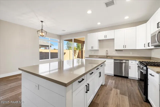 a kitchen with stainless steel appliances granite countertop a sink stove and cabinets