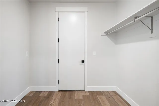 a view of walk in closet with wooden floor