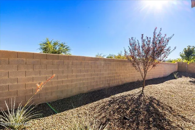 a view of a dry yard with wooden fence