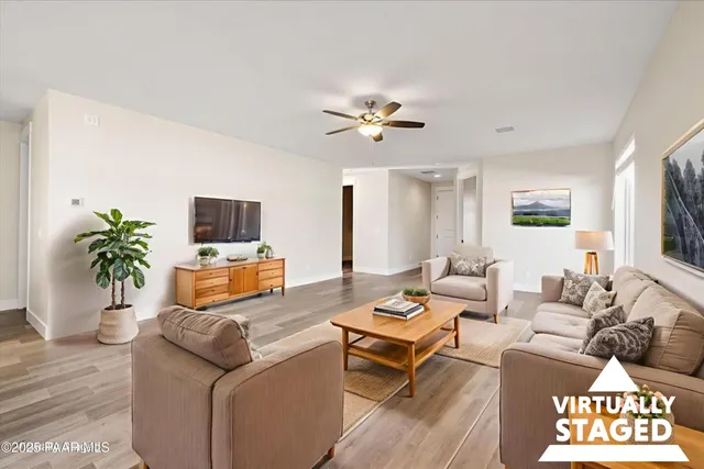 a living room with furniture a chandelier and a wooden floor